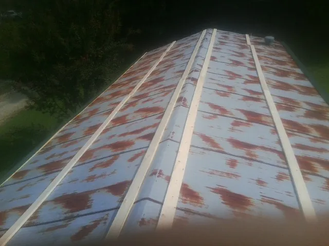Rusted metal roof panels with new wood purlins before replacement — Storm Damage Roof Repair in Kathryn by Roofing Brothers