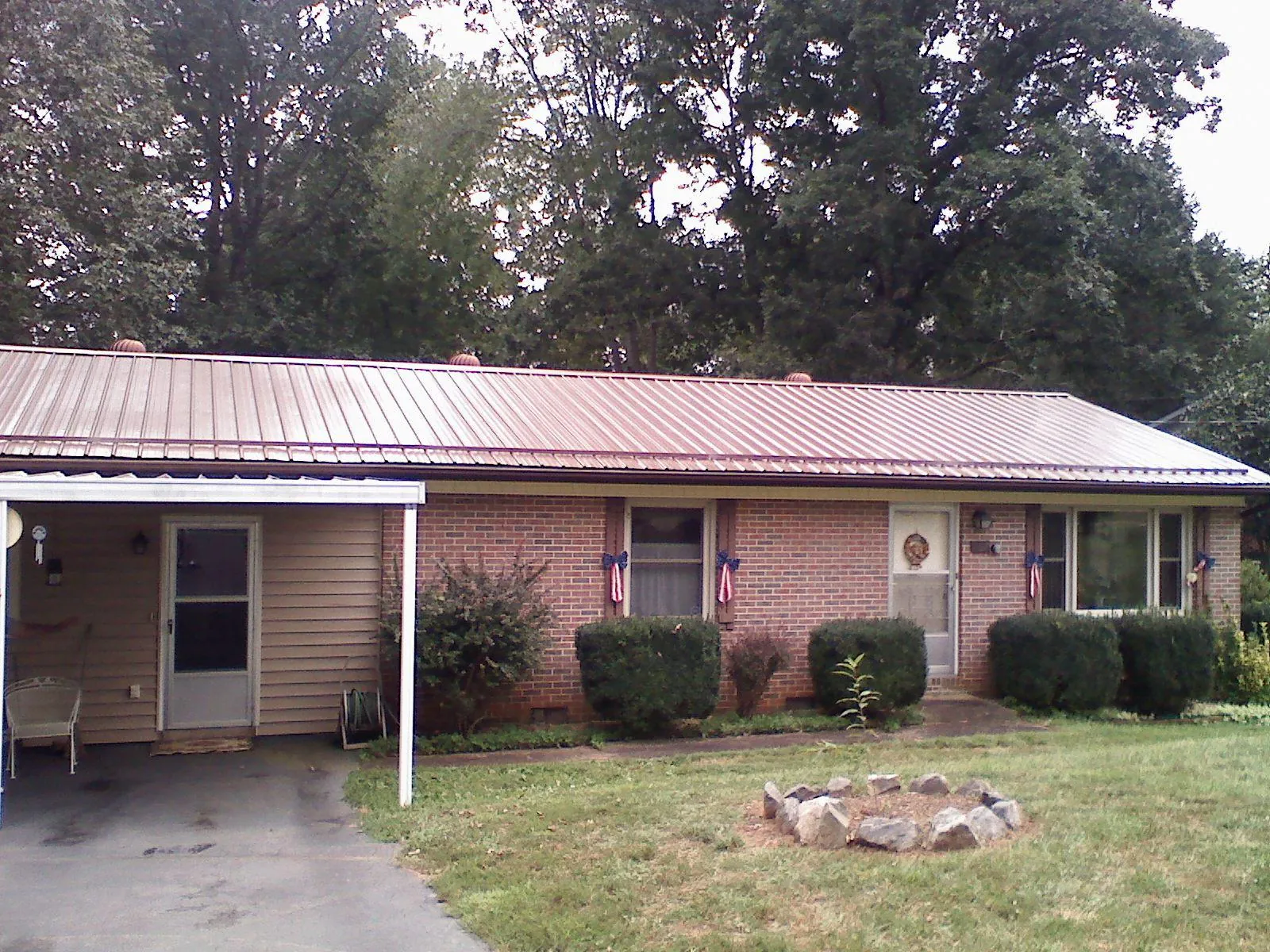 Bronze metal roof and carport on a brick ranch home — Roof Repair work by our crew in Kathryn