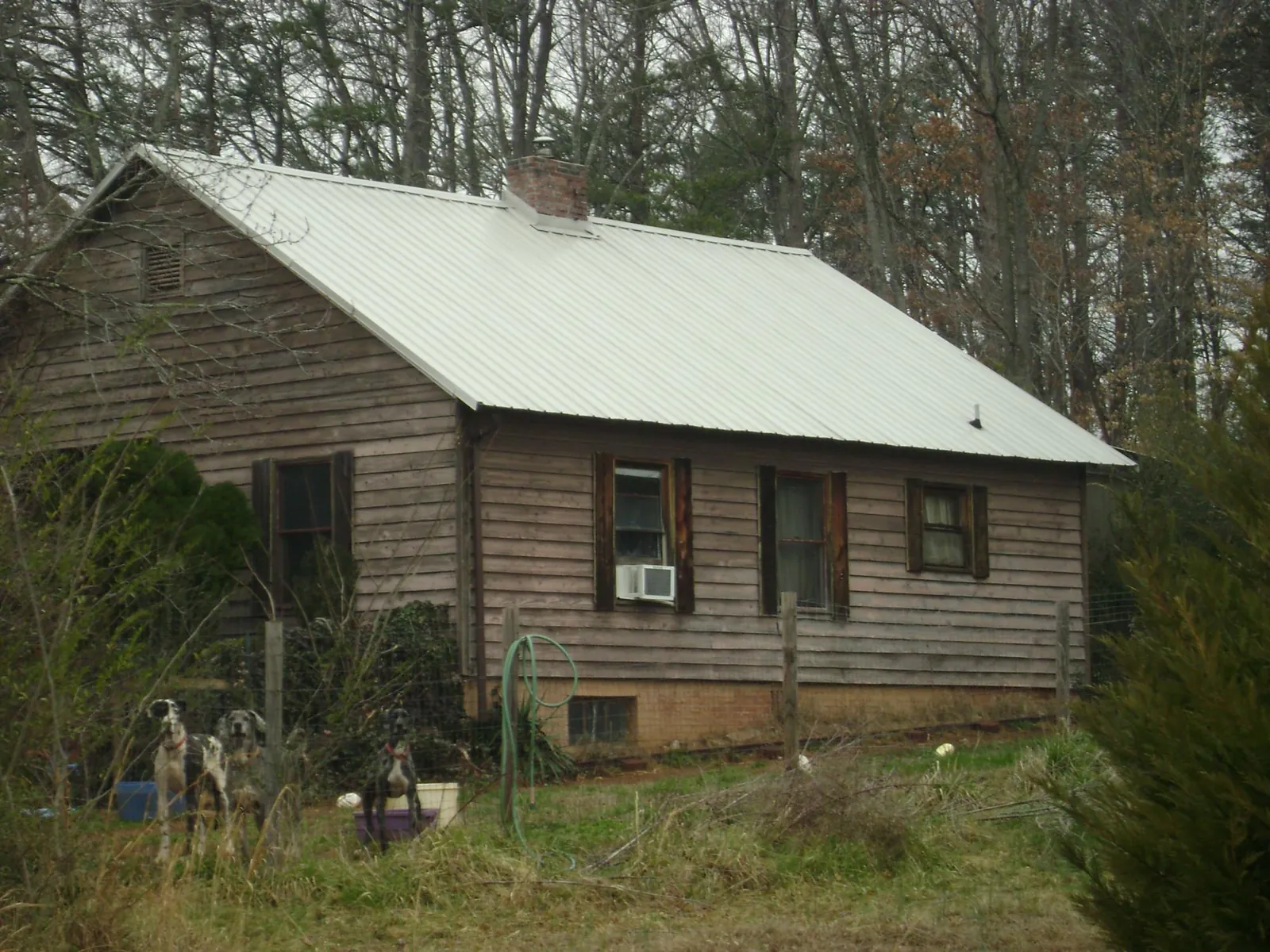 White metal roof on an old wood sided farmhouse, from a Metal Roof Installation job in Kathryn